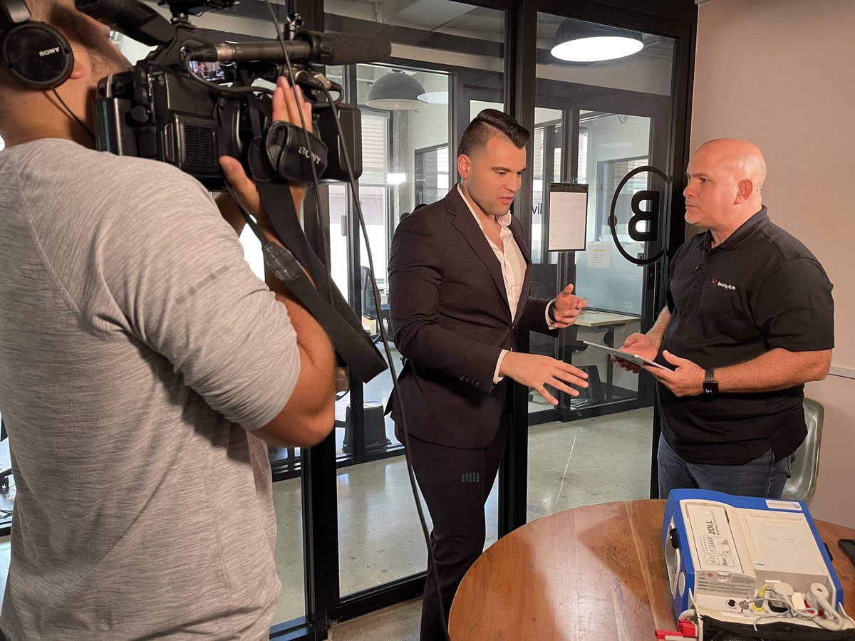 RealityHubXR's tweet photo. Edwin Riviera, right, demonstrates to Gio Insignares of Miami ABC affiliate WPLG-TV, how augmented reality plays a key role in Reality Hub, a metaverse training system for hospitals.  Miami-based CG1 Solutions recently launched a national private beta test for Reality Hub https://t.co/Ssy4XKMtPk