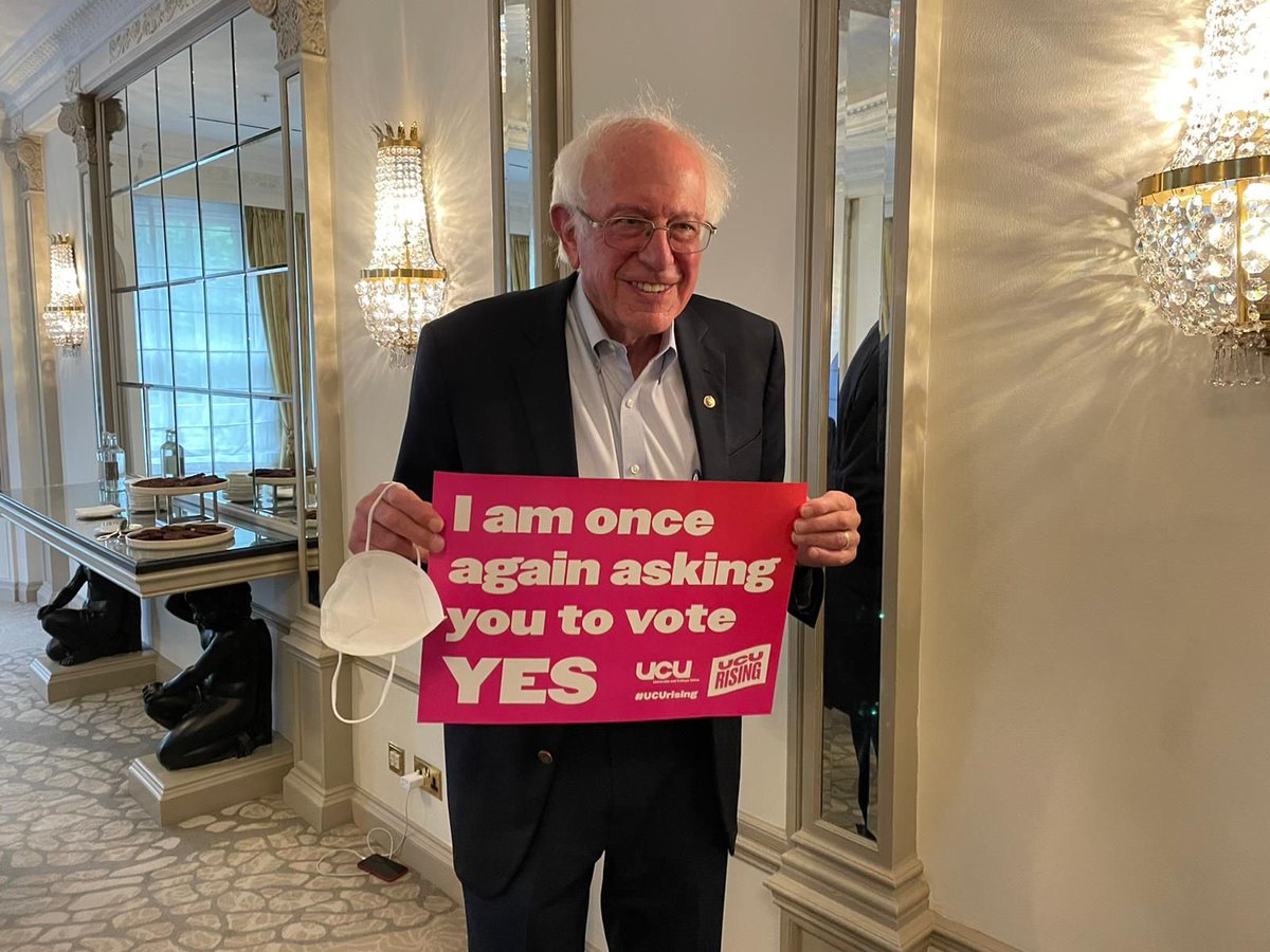 Bernie Sanders holding sign reading ‘I am once again asking you to vote YES’