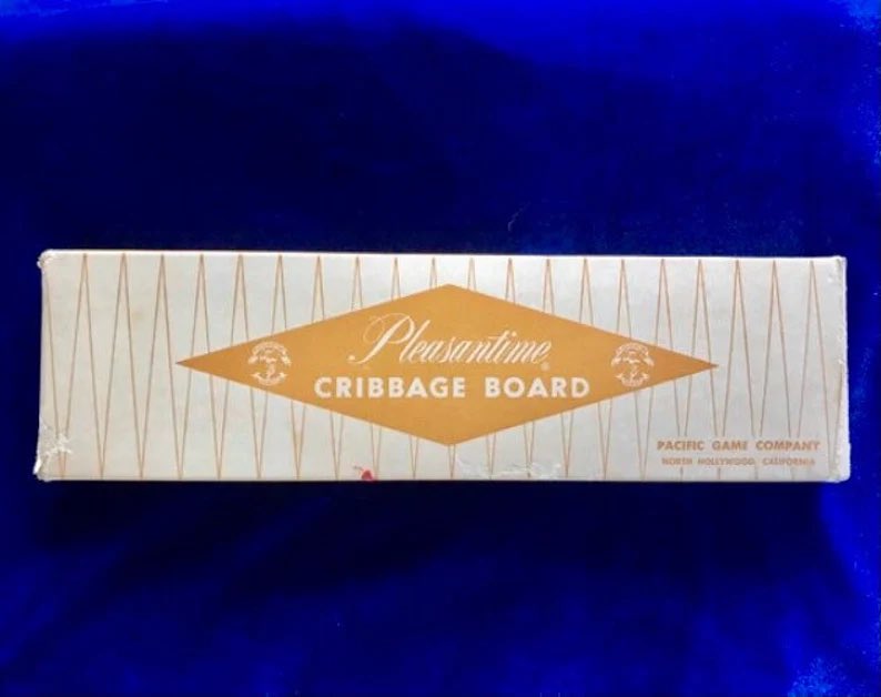 Yellowonetsy's tweet photo. A vintage wooden Pleasantine cribbage board, pegs, instructions &amp; original box. Made by Pacific Game Company during the 1950's. This board looks like new. Pegs inside are made of wood. For sale at https://t.co/92BjKTFNLm. #vintagegames #cribbage #vintage #CribbageBoard https://t.co/eFs5go24Va