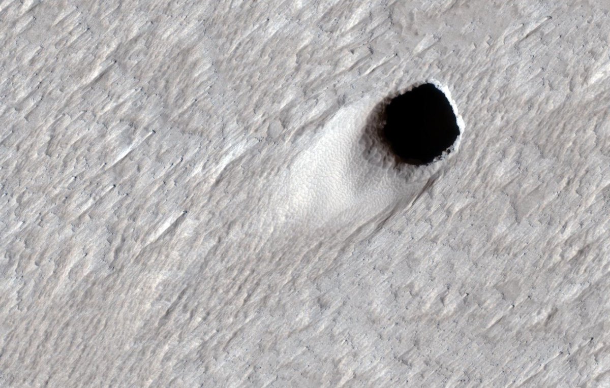 Our Mars Reconnaissance Orbiter spotted this pit. It's about 160 feet (50 meters) across, and likely formed when the roof of a lava cave collapsed. The work of NASA scientists studying lava tunnels on Earth may someday inform future Mars exploration.