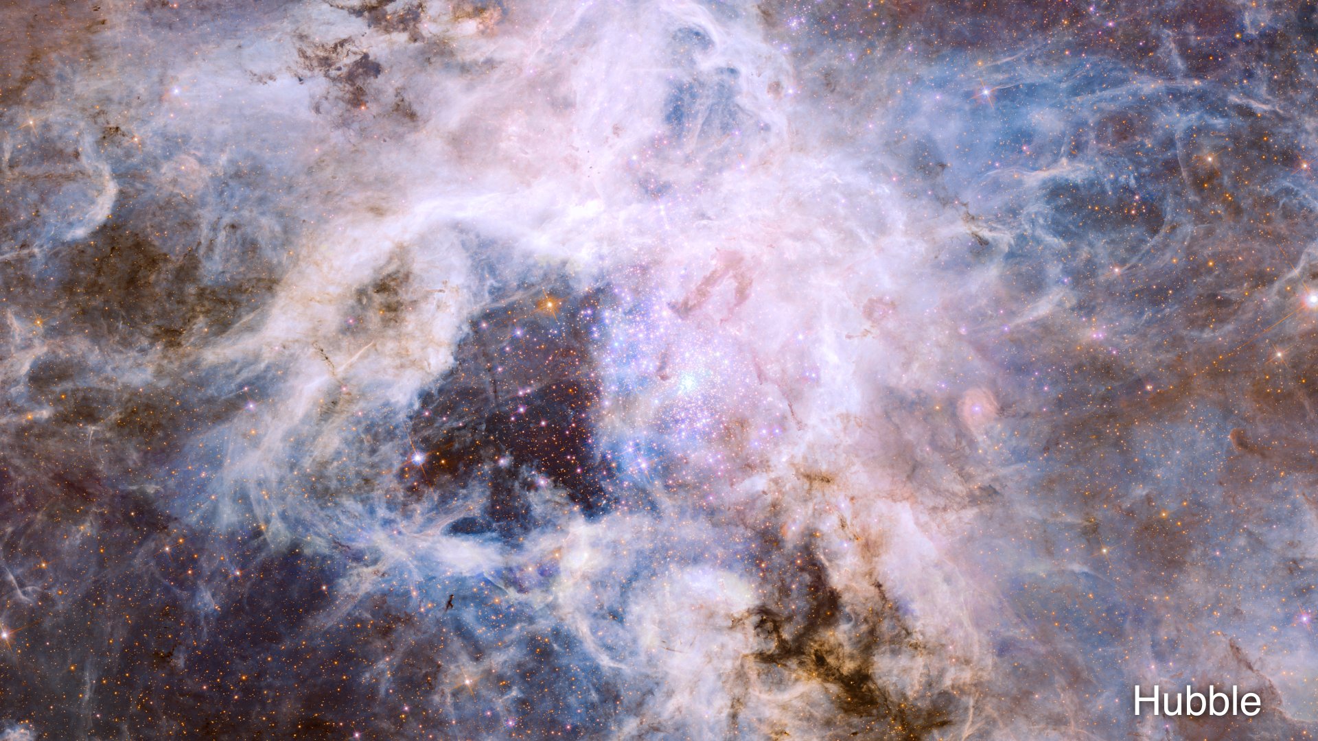Pale, nebulous clouds throng around a darker central area with a cluster of sparkling stars. These clouds are interspersed with darker filaments of deep brown and light blue. Orange stars peer through the clouds throughout the image.