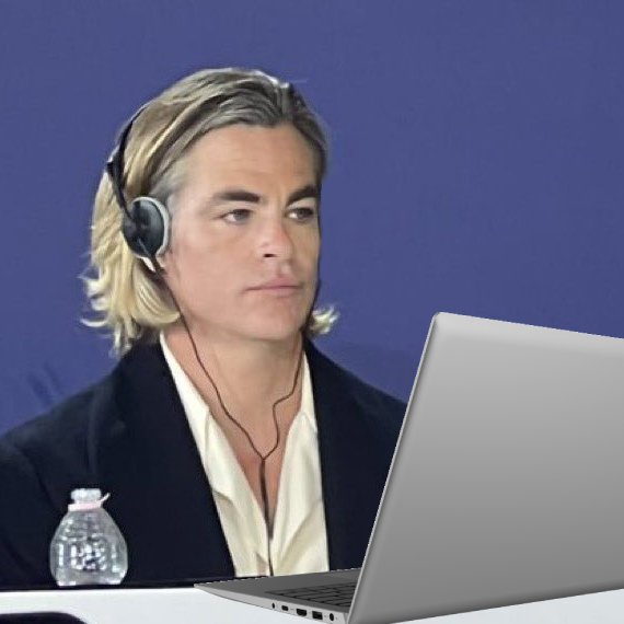 Chris Pine with headphones on, and a laptop in front of him. 