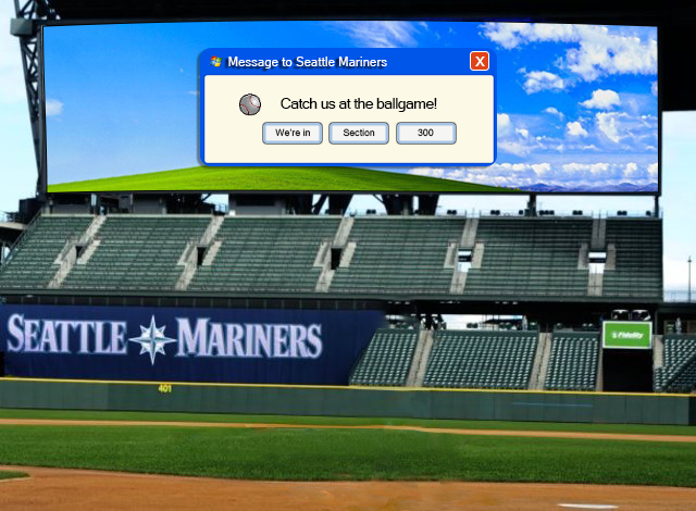 The big screen at T-Mobile Park displaying a Windows XP bliss background with a Windows XP pop-up. The pop-up is titled, 