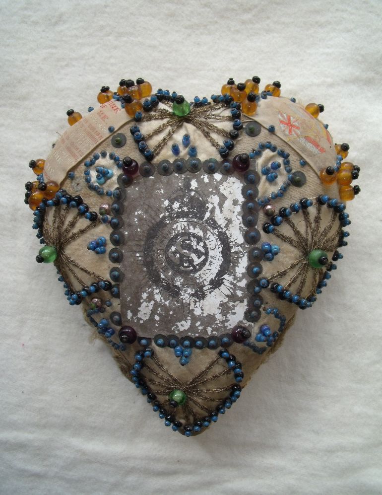 AncientHouseMus's tweet photo. We are celebrating #SewingMonth with this heart-shaped pin cushion from World War I. Soldiers sent these home to loved ones. At the centre is a regimental badge and on the edge is a poem entitled ‘Think of Me’. This was on display in our exhibition ‘Thetford Remembers’ in 2014. https://t.co/RdNWONmI7Q