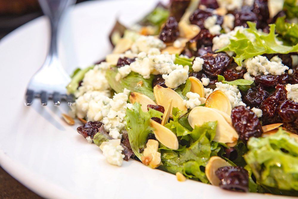 If you can ever become obsessed with a salad, surely this is the one: Our Bada Bing is topped with almonds, dried bing cherries, gorgonzola, and a raspberry vinegar dressing. YUMS.