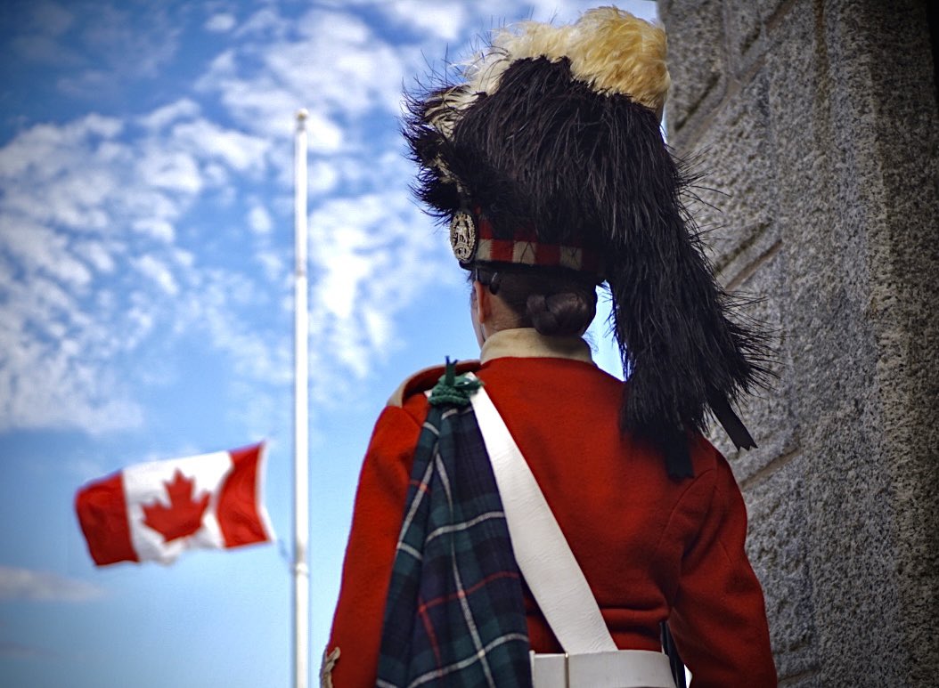 AlexaMacLean902's tweet photo. A Canadian flag flies at half-mast over the shoulder of a gate guard at the Halifax Citadel National Historic Site. Flags are lowered to half-mast throughout the city as a mark of respect following the death of Queen Elizabeth II. https://t.co/wunjTdeoXU