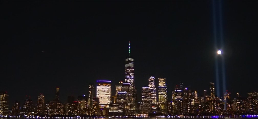 Tonight's Tribute in Light. The moon is visible between the beams of light.