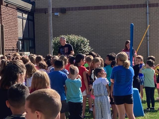 IW_Supe's tweet photo. IW Remembers.  GES students meeting at the flagpole to hear Mr. Harkins speak about 9/11.  It was great to see classrooms of students discussing what it means to be a patriot.   #iwraiders https://t.co/sM6duDwLfC