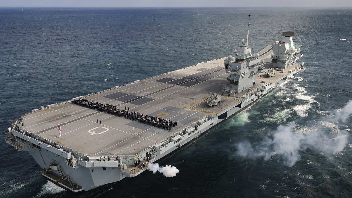 NavyLookout's tweet photo. Ships company muster on the flight deck of @HMSQNLZ mid-Atlantic for 96-gun salute and to mark the passing of 'the boss'   (and the ship's Lady Sponsor)

#QueenElizabethII https://t.co/Up2m9BhVkc
