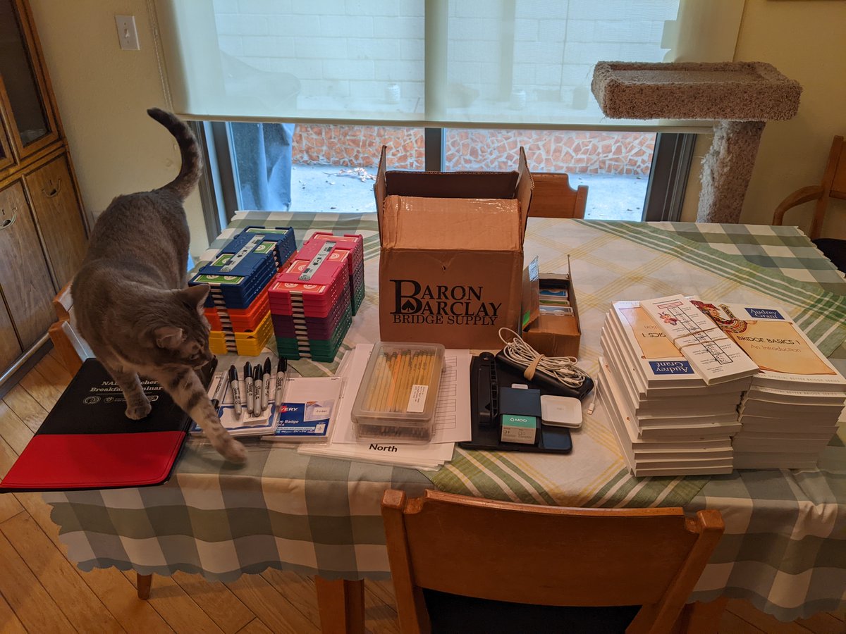 BridgeMojo's tweet image. Supplies for my first in-person beginning bridge classes in three years, starting this week. Dragon inspecting everything for suitability. :) bridgemojo.com/bridge-introdu…