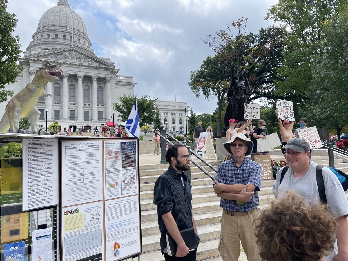 Just another day in Madison: anti-evolution booth next to topless reproductive rights protestors. wiabortionfund.org