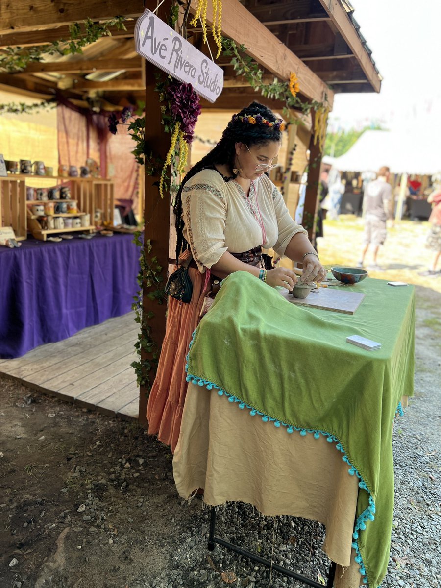 Averiverastudio's tweet photo. My mama took an action shot of me sculpting a mushroom jar at the faire 🍄 🐉💕

Pay no attention to the mysterious lump under the tablecloth haha 👀 https://t.co/HOy35fR8Fy