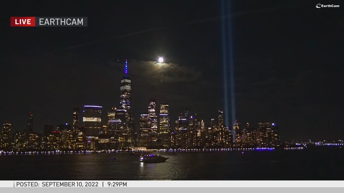 Matt_Brickman's tweet photo. A nearly full moon between One World Trade Center &amp; the #TributeInLight. https://t.co/X7QVFcB0YV