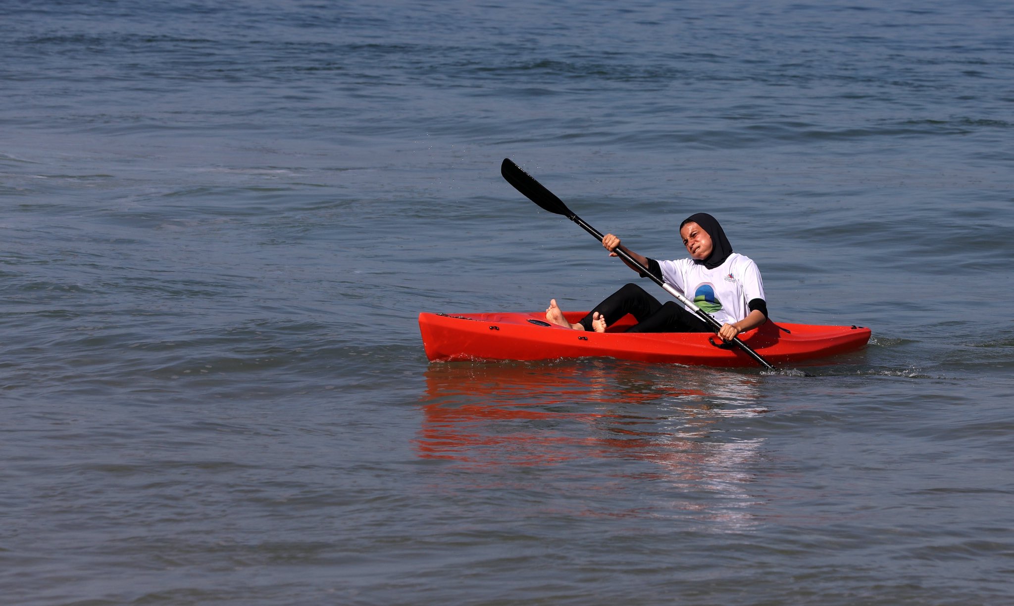 قتاة فلسطينية تجيد مهارة التجديف عبر شاطئ بحر غزة
