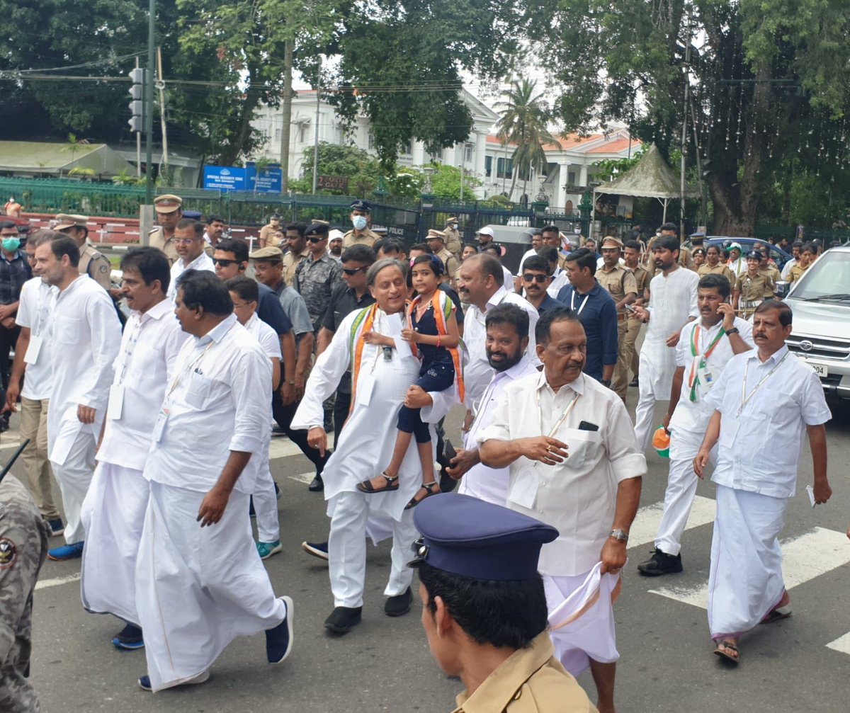 ShashiTharoor's tweet photo. While marching along, found a young girl on the sidelines desperate to meet ⁦@RahulGandhi⁩. Took her to him myself, she handed over a flower and was then safely returned to her father. #BharatJodoYatra in Thiruvananthapuram https://t.co/n0aJJFSlQh