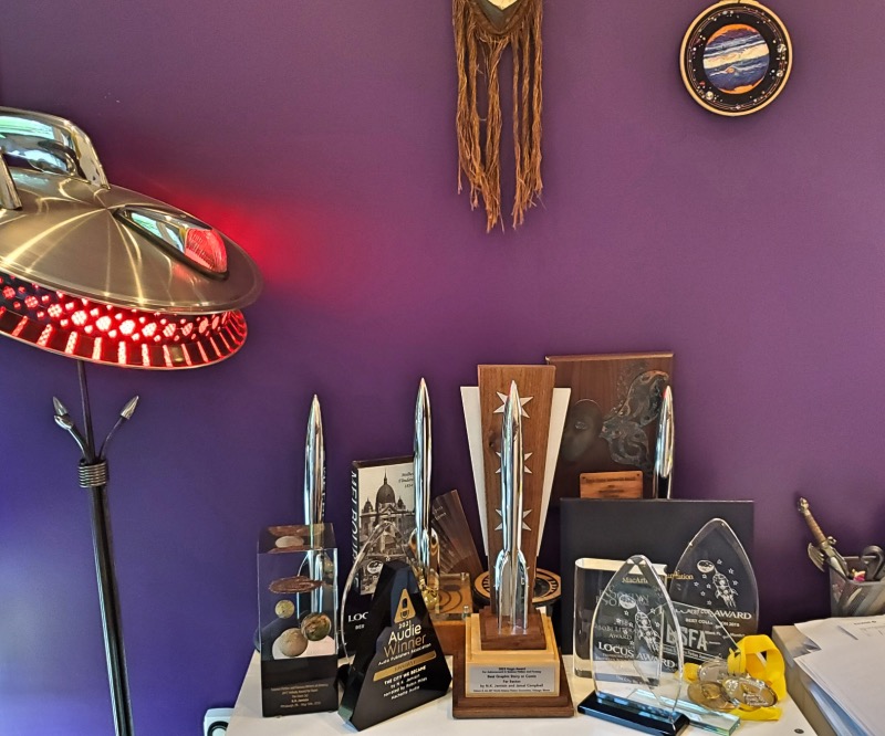 The new Hugo arrived! Now I need to figure out how to arrange my awards table so that you can actually see all 5 of them. I might have to trade up to an awards cabinet. And yeah, it's a flex, so I turned on the spaceship lamp to make it special, lol. (Ignore my messy desk pls)