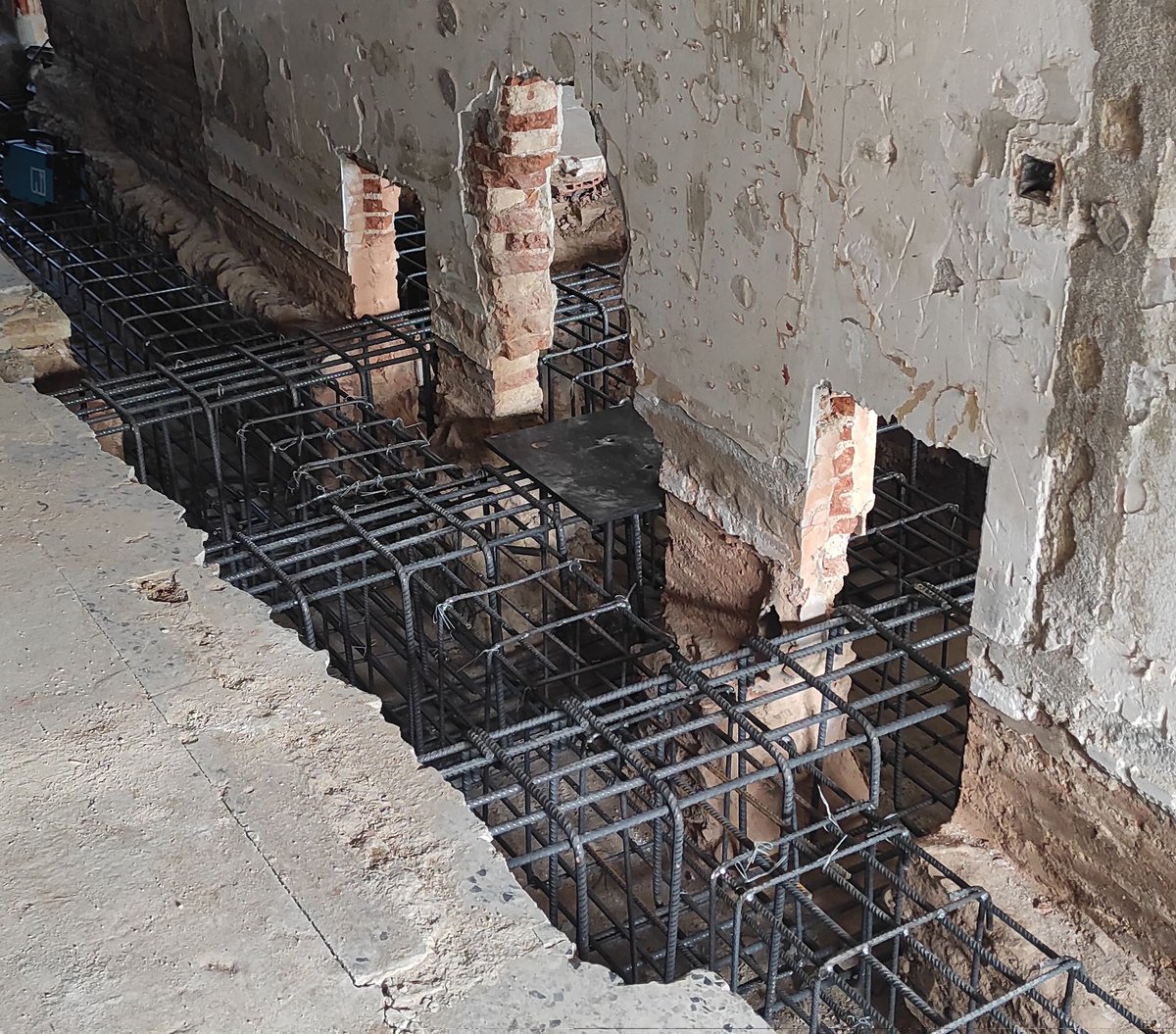 BCNstructures's tweet photo. Revisió dels reforços dels fonaments d'estintolament de 2 trams per a permetre l'enderroc de 10m de mur entre locals de PB de dos edificis de PB+3. A la imatge, unes bigues-pont que rebran el pilar central de l'estintolament i repartiran la càrrega als pous laterals ja executats https://t.co/z9GweDZ4mi