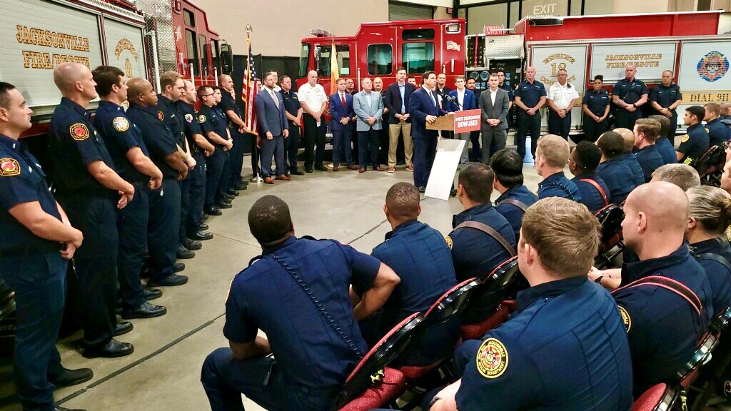 CityofJax's tweet photo. For the 2nd year in a row, @GovRonDeSantis is handing out $1,000 to all 1st responders, EMT, and sworn law enforcement in the State of Florida.  Today, members of @THEJFRD received their checks from the Governor.  Thank you so much for your priceless commitment to our safety! https://t.co/SnOtTrUcw9