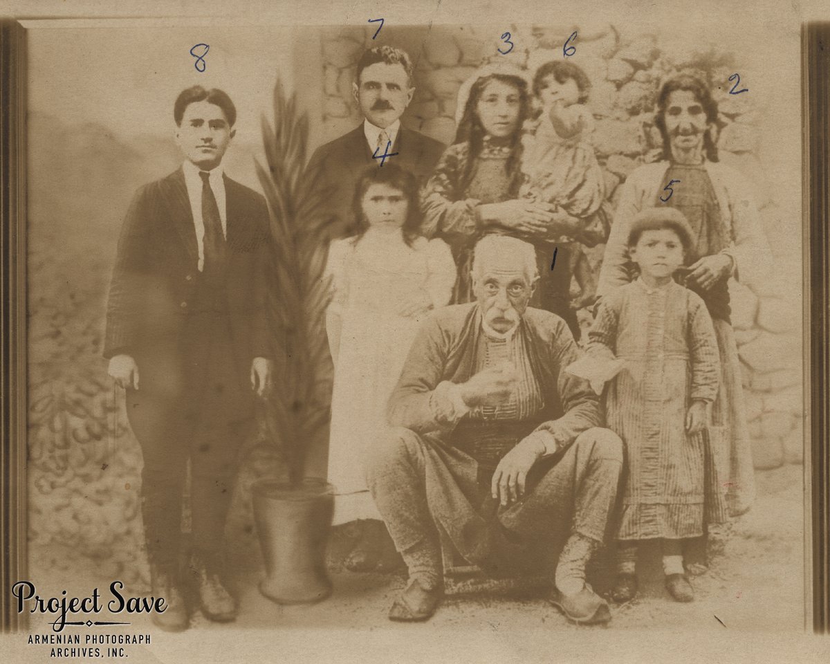 Composite family photograph. The older photograph (c. 1910) was taken in the Village of Nipshee, Palou, near Kharpert. The Two men in suits and a potted plant were added, covering other non-family members in the original photo.

#ProjectSAVE #familycomposite #OttomanEmpire