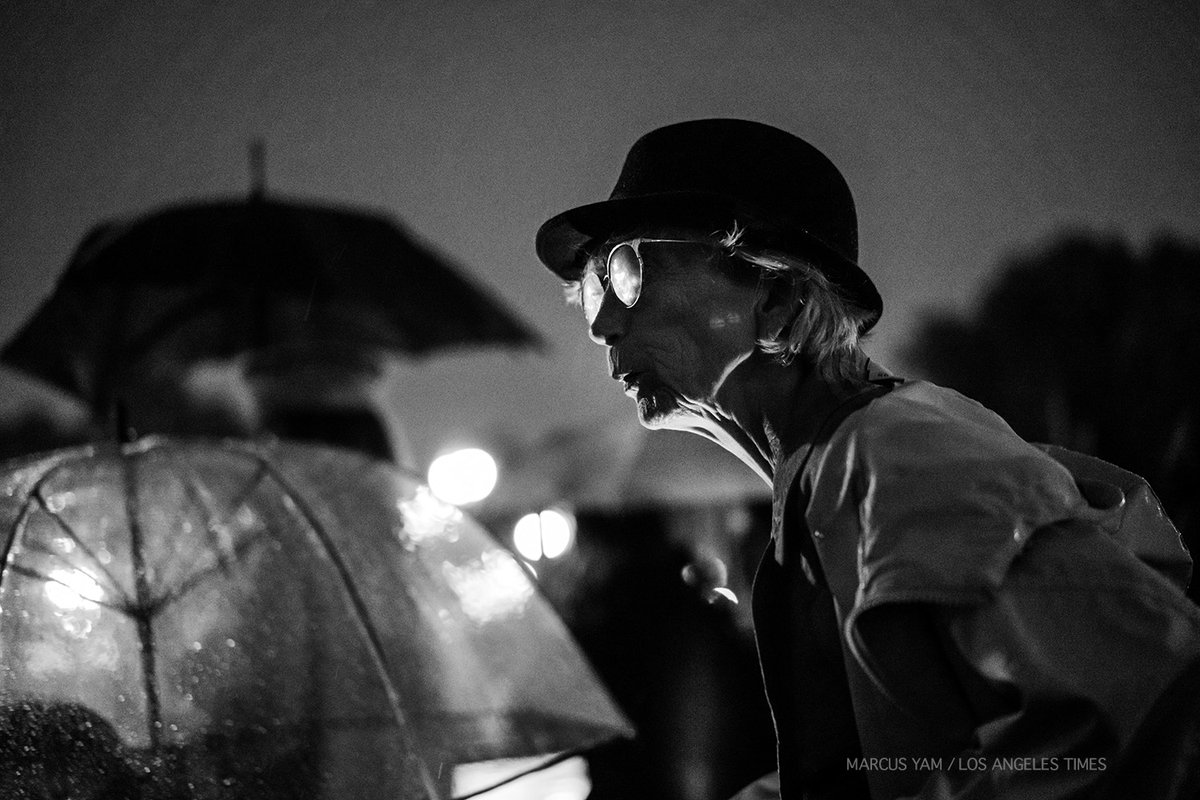 yamphoto's tweet photo. DISPATCH: Buckingham Palace. Rain pours but does not deter. Hundreds slowly gather. Hair pushed aside, faces glimmer wet. Someone yelled, "long love the queen." Camera flash sparkles the scene. Proper applause. A hearse bearing the late Queen Elizabeth II arrives. Everyone looks. https://t.co/MqzlIaNtAD