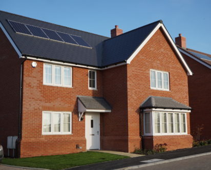 Why is solar PV not mandatory for new build homes?

When I do see some panels on a new development, it doesn't cover the roof. It is a suggestion of sustainability, a nod, the bare minimum.

Why aren't new homes all designed with south facing roofs?

Easy wins missed time & again