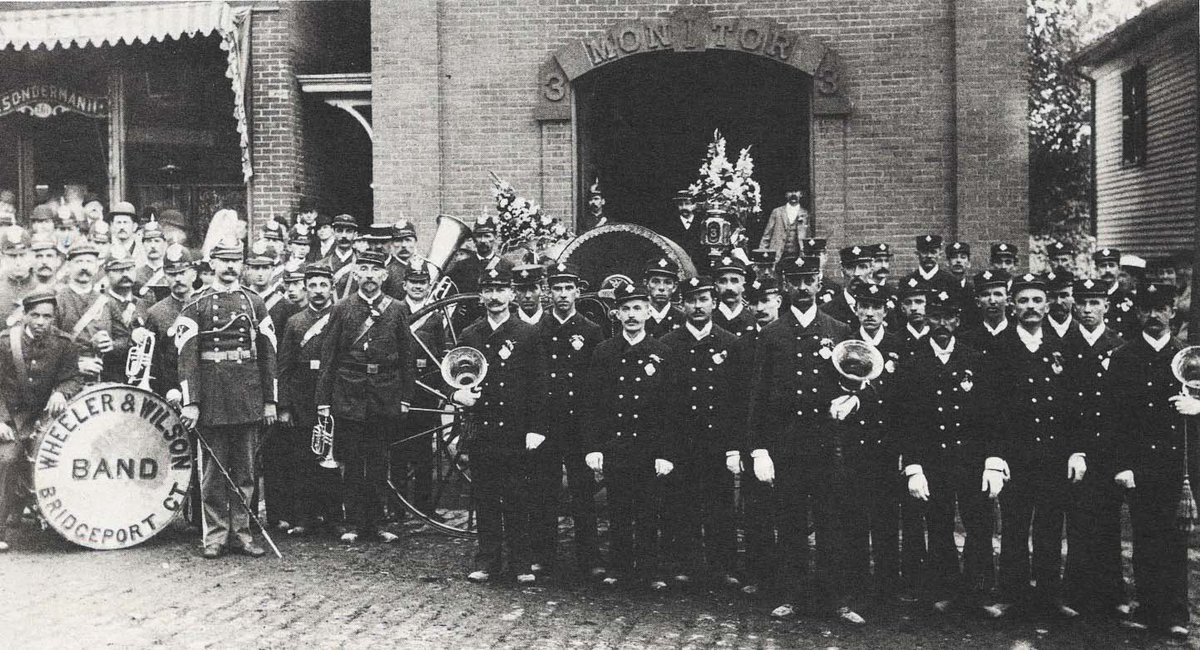 In September of 1893, the annual Firemen’s Parade took place in Waterbury. Pictured here are the Monitor Hose Co. No. 3 and the Wheeler &amp; Wilson Band. They are pictured in front of the headquarters at 265 Bank Street. 
#WaterburyWednesday #CTHistory #Waterbury