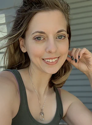 Photo of Jennifer Strange, a white woman with light brown hair wearing an olive green tank top and smiling