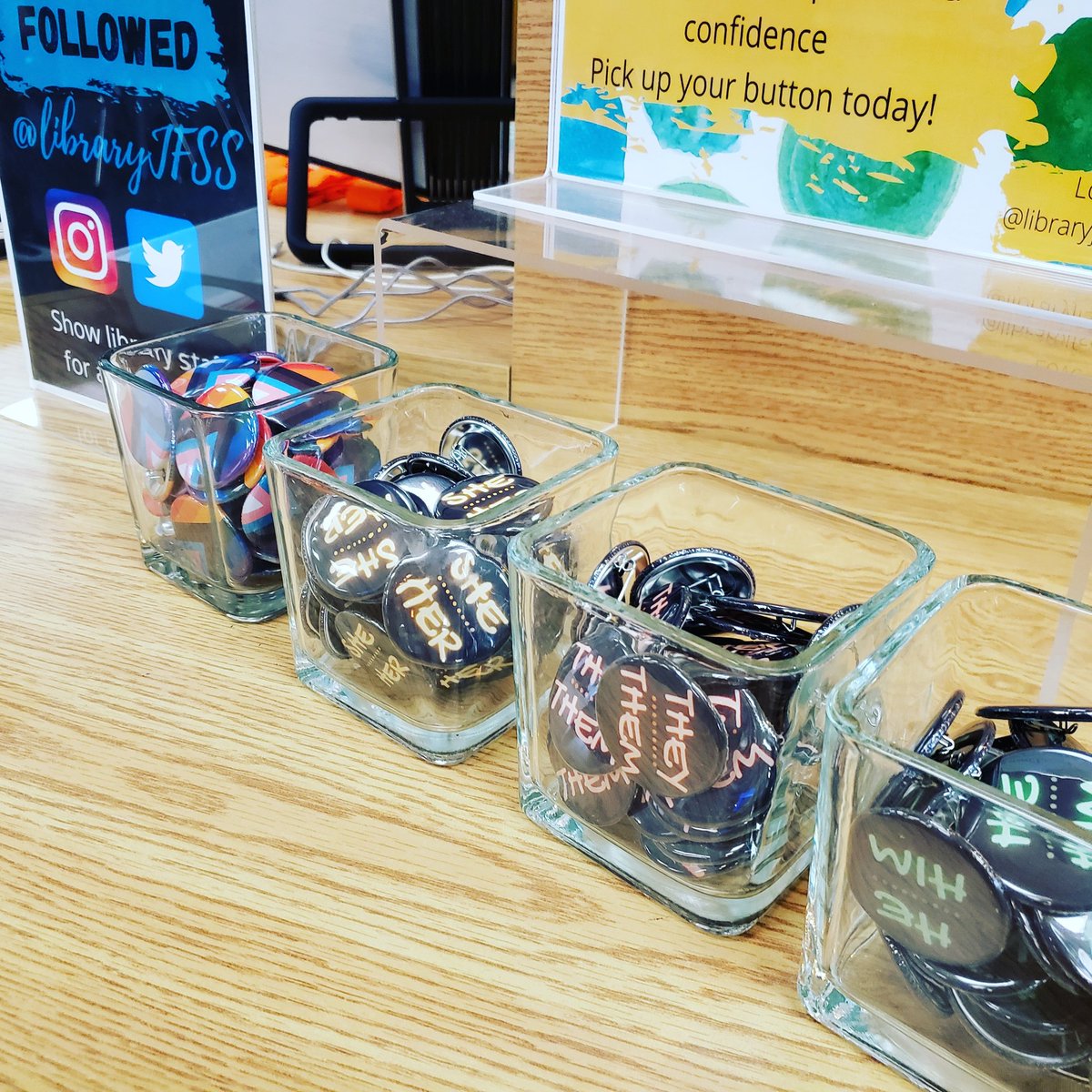 LibraryJFSS's tweet photo. They're BACK @jfssSAC !  Pronoun buttons have been refilled.  Come and pick one up - located in front of the circulation desk.  #pride @PDSB_Libraries @oslacouncil https://t.co/bjQDpfQxo1