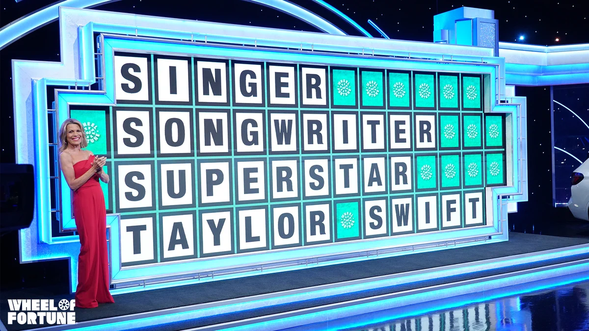 Vanna stands in front of the puzzleboard, which says, "SINGER SONGWRITER SUPERSTAR TAYLOR SWIFT."