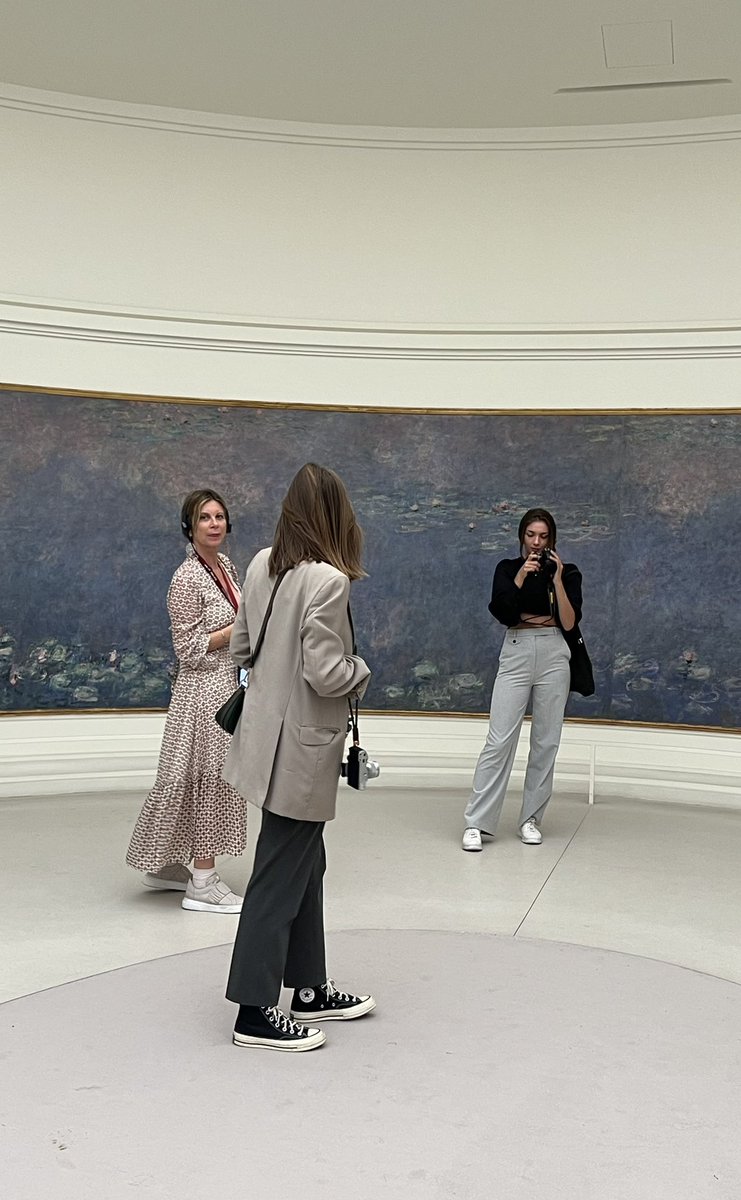 カメラを片手に互いに取り合うパリジェンヌ。