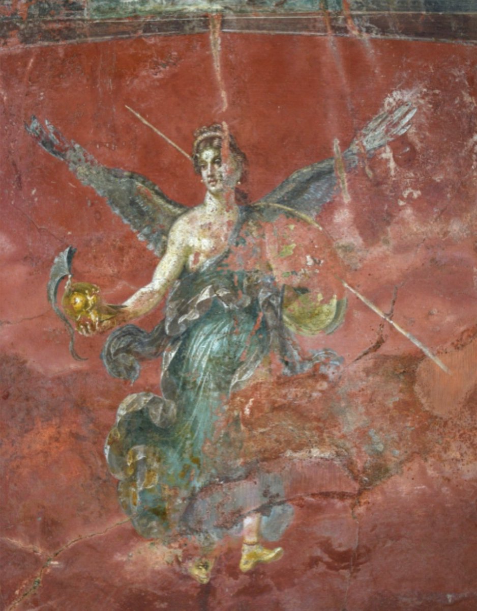 Winged Victory. Wall fresco from Pompeii, Italy. Dated 64 AD. Victory was the Roman personification of the Greek goddess, Nike. The winged goddess is shown holding spear and shield in left hand, and helmet in right hand. Archaeological Park of Pompeii.
