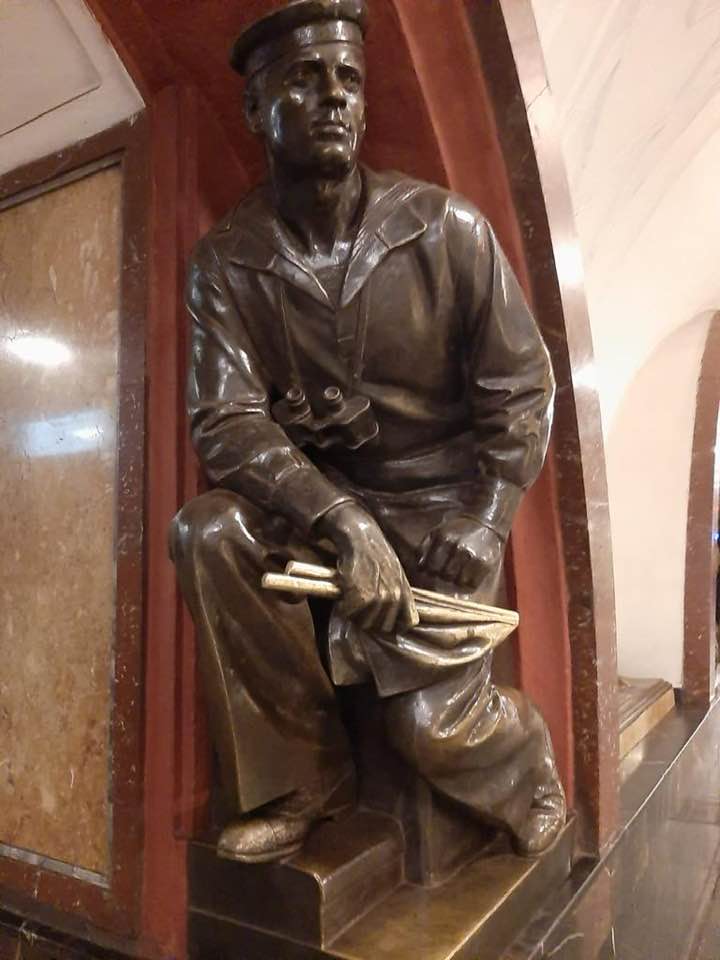 Это скульптура матроса-сигнальщика на станции метро "Площадь Революции" и ее прототип- офицер ВМФ СССР Олимпий Рудаков. 
История, связывающая его с королевой Елизаветой, почти невероятная.