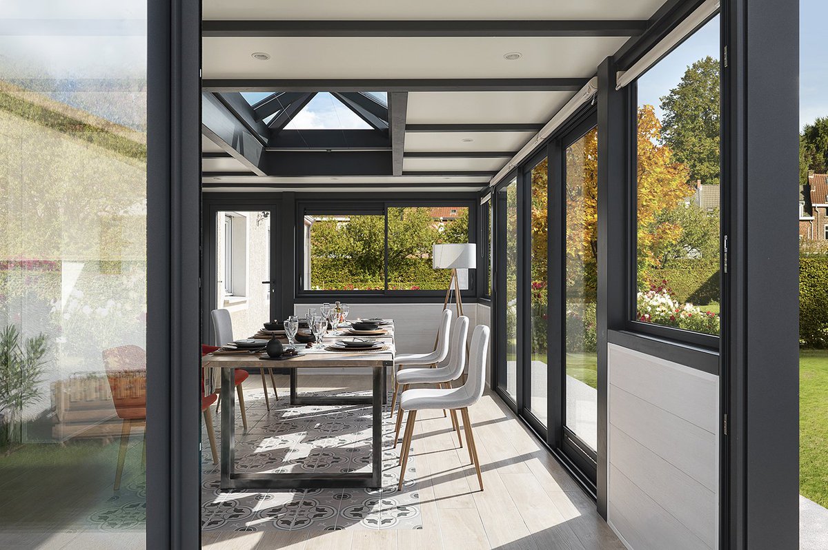 🍂 L'#automne dans une #véranda... Pour admirer les couleurs du jardin changer, depuis les grandes baies vitrées. 
Découvrez nos réalisations de vérandas salle à manger : vie-veranda.com/nos-realisatio…
