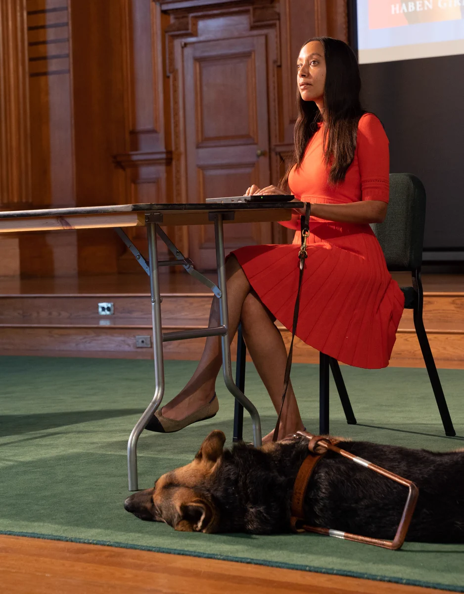 Haben Girma and dog Mylo on stage in the Phillips Academy Chapel