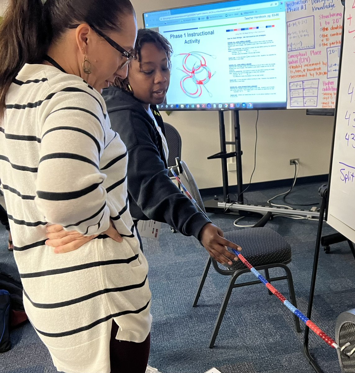 SCUC teacher exploring teaching strategies using a beaded number line, magnets and chairs