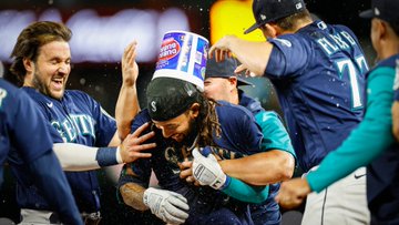 Chris Flexen, Ty France and Luis Torrens embrace J.P., putting a gum bucket on his head. 