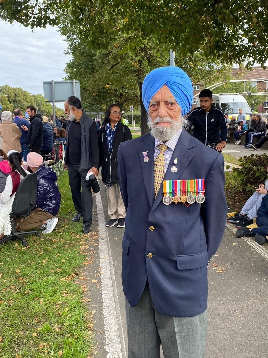 100 year old Rajindar Singh Dhatt waits for the Queen's procession to pass in Hounslow, West London with a single rose in his hand to pay his respects