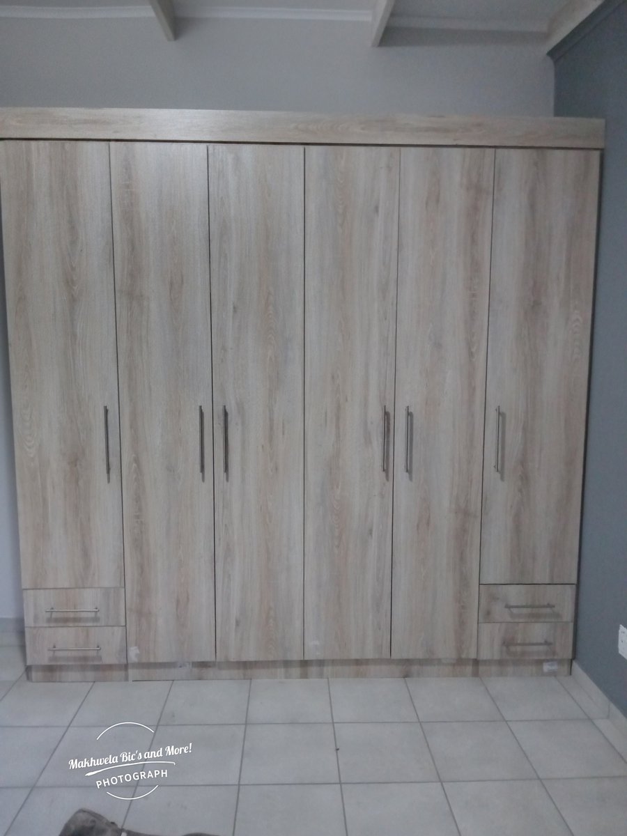 A wall wardrobe for two people, each having a set of two drawers, shelves and a hanging space.