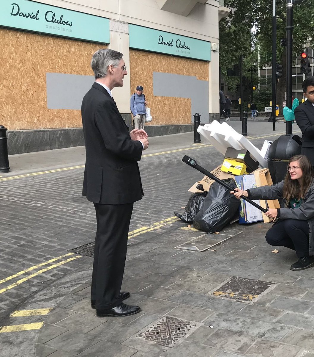 Business Secretary Jacob Rees-Mogg in front of a pile of rubbish and a closed business.