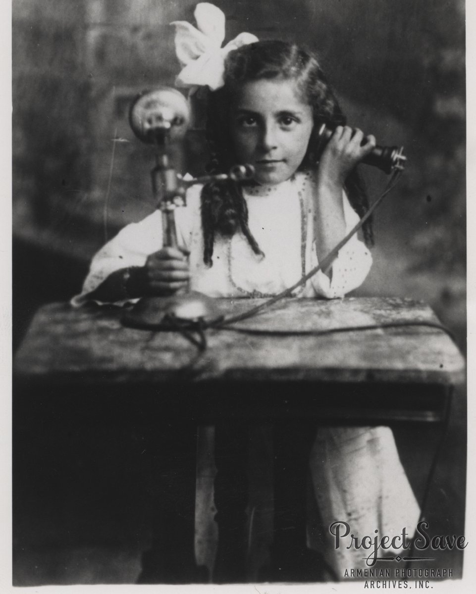 Eugenie Kaznajian poses with the telephone receiver to her ear, Lowell, Massachusetts, c. 1914. 

 #ProjectSAVE #telephone #AT&amp;T #technology
