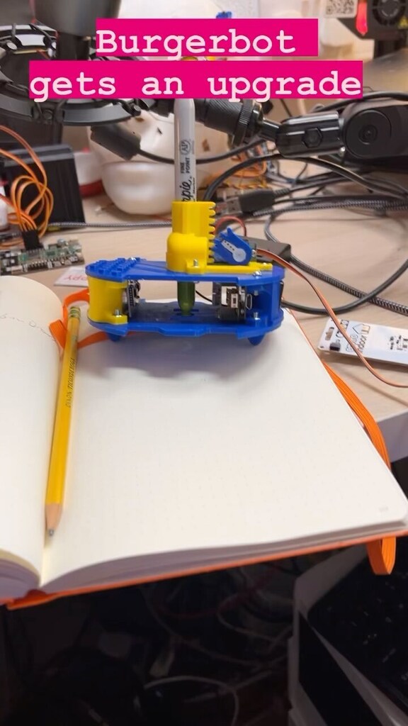 kevsmac's tweet photo. BurgerBot gets an upgrade! It can draw now - the pen is at the very centre making drawing with code a lot easier. #robot #robotics #burgerbot #STEM #fusion360 #3dprinted #engineering #cs #micropython #circuitpython https://t.co/DFMsupe3F1 https://t.co/YMpXawrkHN