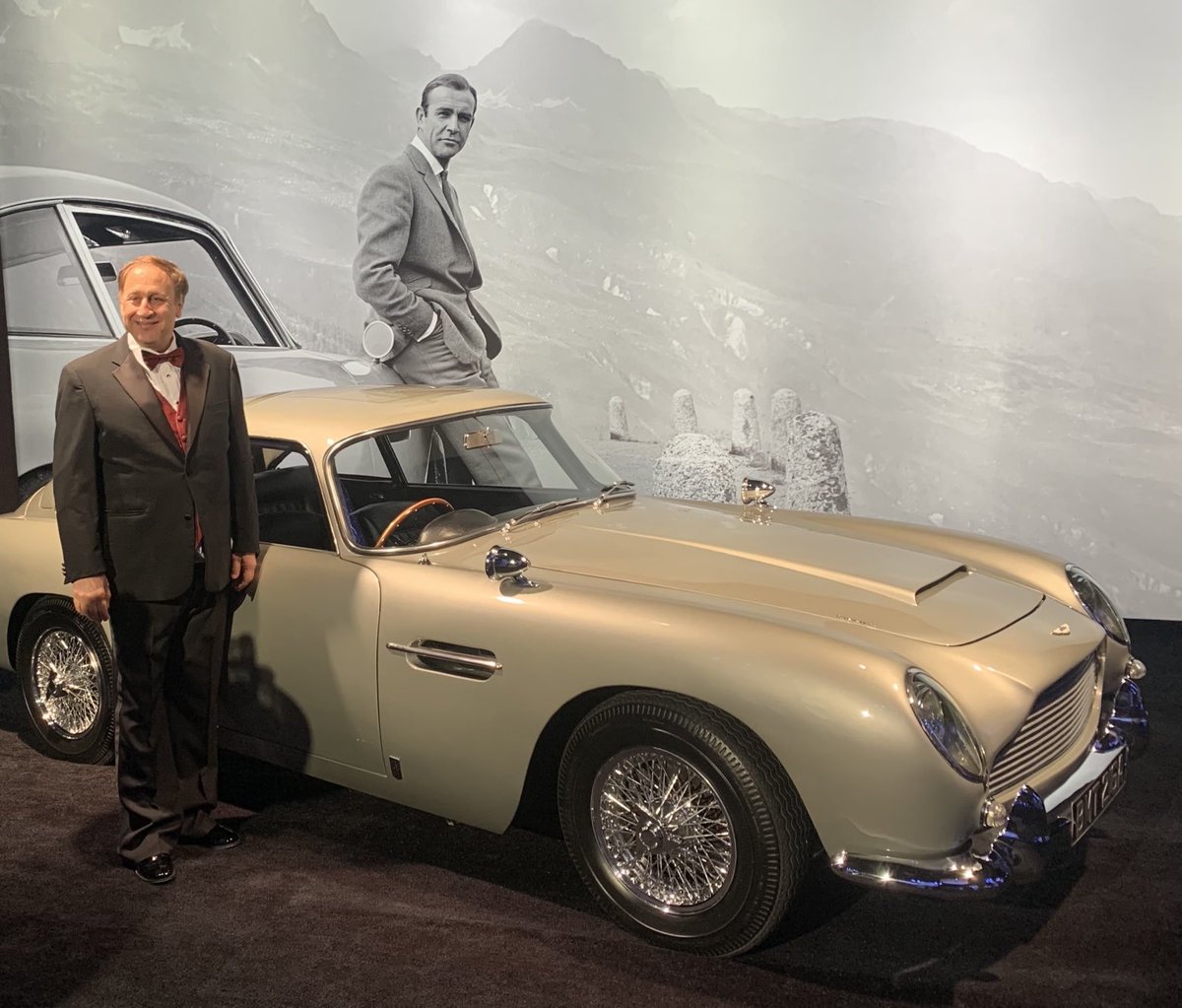 I am at a charity dinner in Los Angeles honoring Barbara Broccoli and Michael Wilson, longtime producers of the James Bond movies over several decades. Here I am next to a Bond-era baby blue Aston Martin. Similar to what he drove in Goldfinger,  circa 1964.