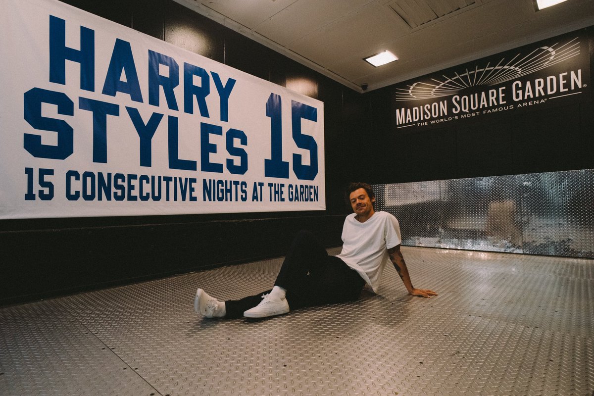 TheHarryNews's tweet image. Harry sitting next to his banner at Madison Square Garden!