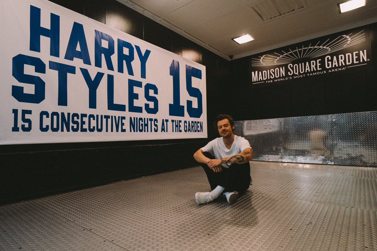 TheHarryNews's tweet image. Harry sitting next to his banner at Madison Square Garden!