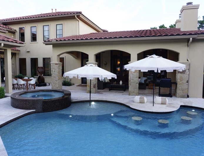 Custom pool and spa with built-in seating and sun shelf.  #AustinPoolBuilders #AustinSwimmingPools #ReliantPools