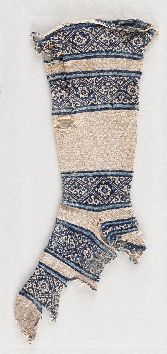 Blue and white patterned socks, with geometric patterning, from Egypt. The heels and soles are worn away. 