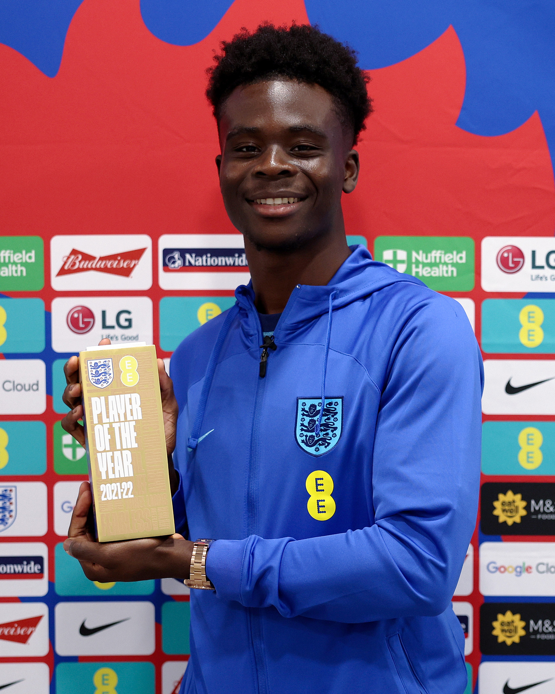 Bukayo Saka poses for a photo with England Men's Player of the Year connected by EE trophy.