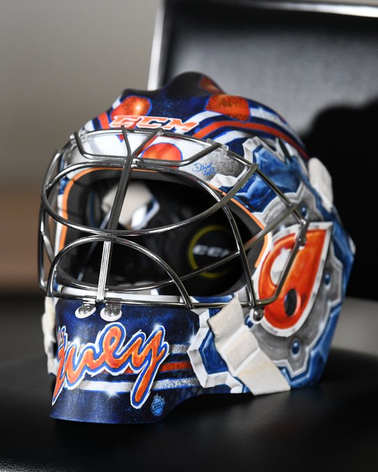 A close-up of Stuart Skinner's new goalie mask featuring a retro design with an orange oil drop and "Stuey" written on the front. 