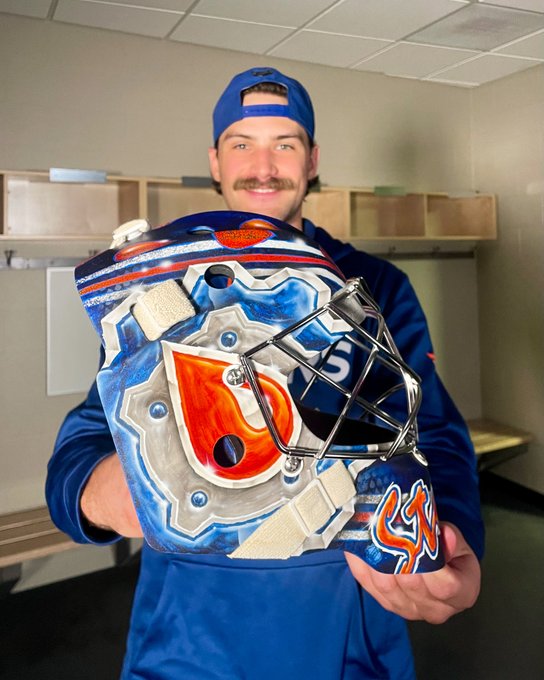 Stuart Skinner smiles while holding up his new goalie mask. 