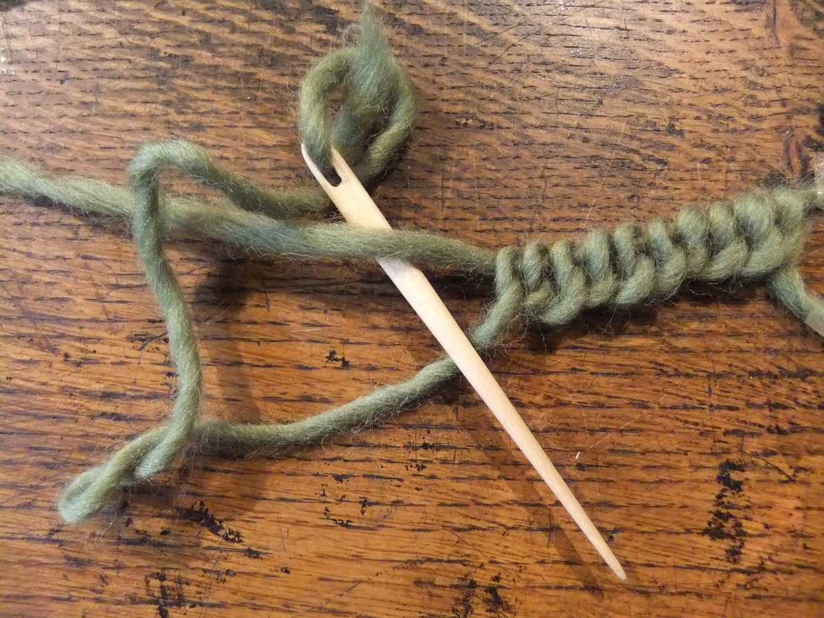 An example of nalebinding, green, with one needle. 